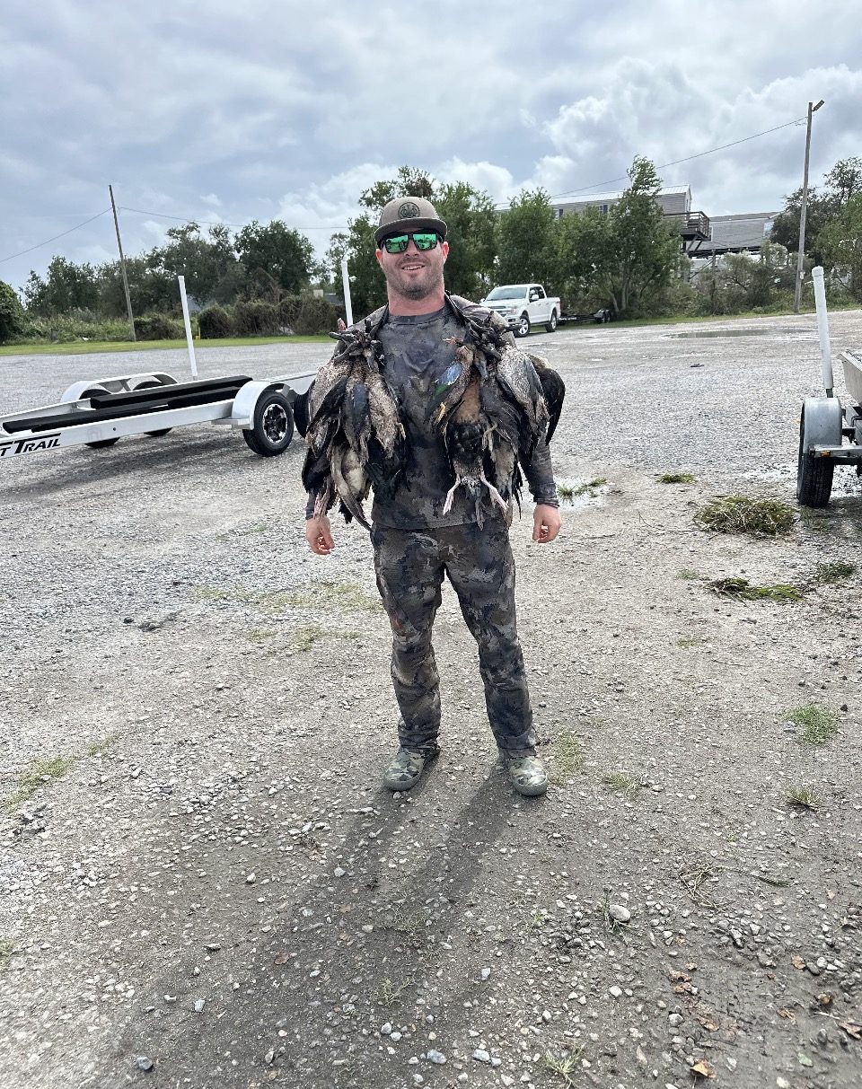 Hunter carrying a strap of ducks back to the truck